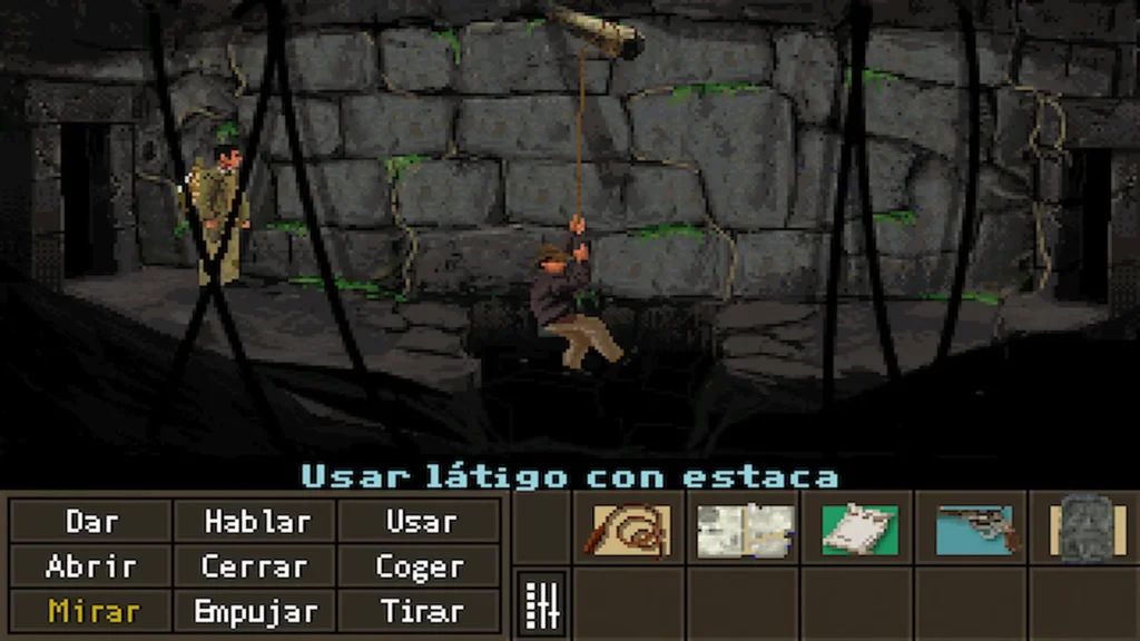Indiana Jones se balancea con el látigo dentro de unas ruinas oscuras en busca del arca perdida.