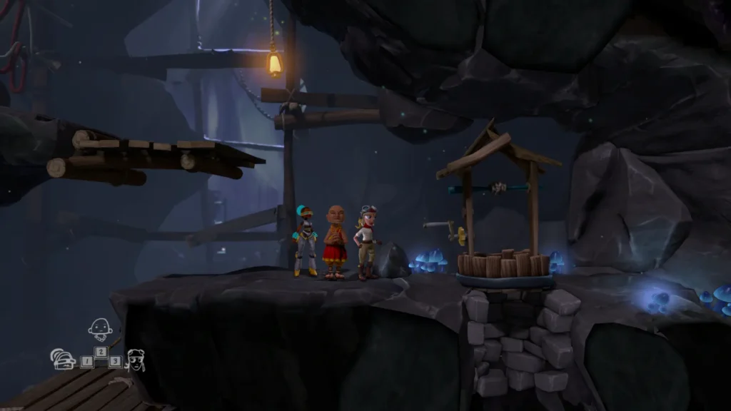 Tres aventureros de The Cave se detienen ante un pozo iluminado dentro de una cueva subterránea.