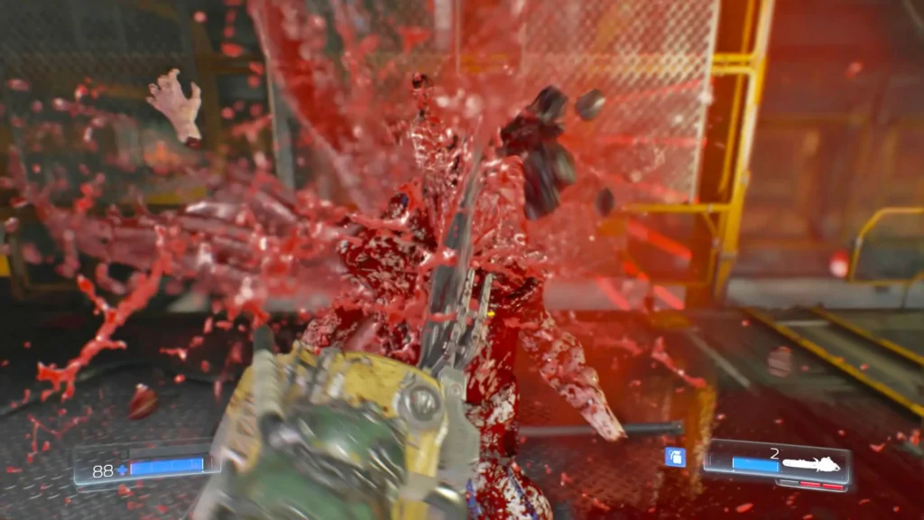 El jugador en Doom (2016) destroza a un demonio con la motosierra, provocando una explosión de sangre y miembros desmembrados.