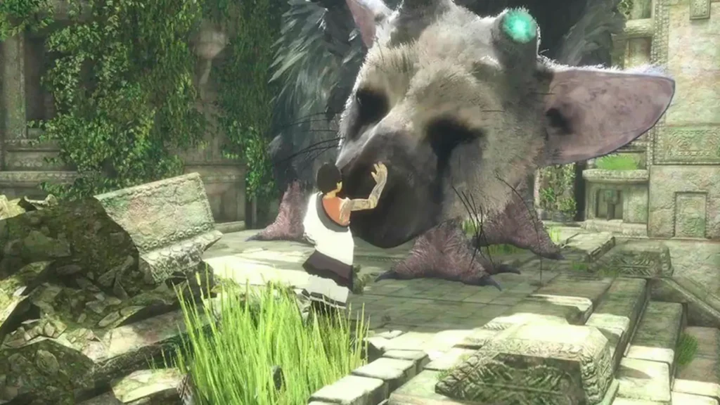 Niño acaricia el rostro de Trico en The Last Guardian entre ruinas cubiertas de vegetación.