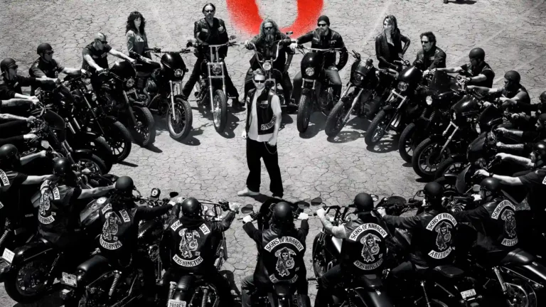 Jax Teller, protagonista de Sons of Anarchy, rodeado de un montón de motores en una calzada gris.