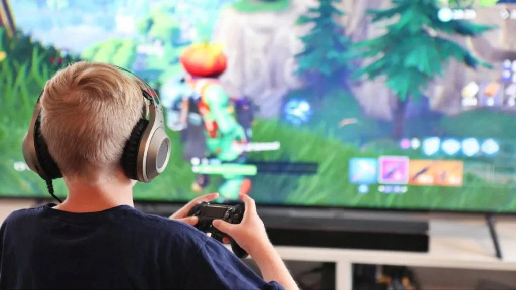 Un niño juega a Fortnite en un televisor, mostrando el molesto fenómeno del troll o "artista" en línea, parte de las situaciones irritantes en los videojuegos.