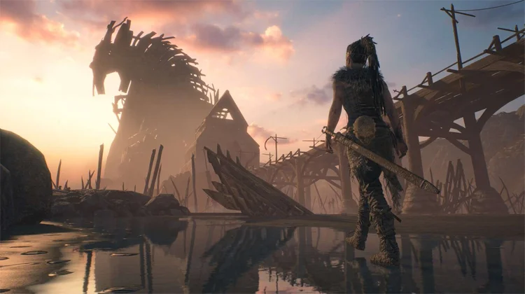 Análisis de Hellblade: Senua's Sacrifice 2 Senua caminando por una playa nórdica en dirección hacia una construcción de madera, otra prueba más de que Hellblade es alucinante.