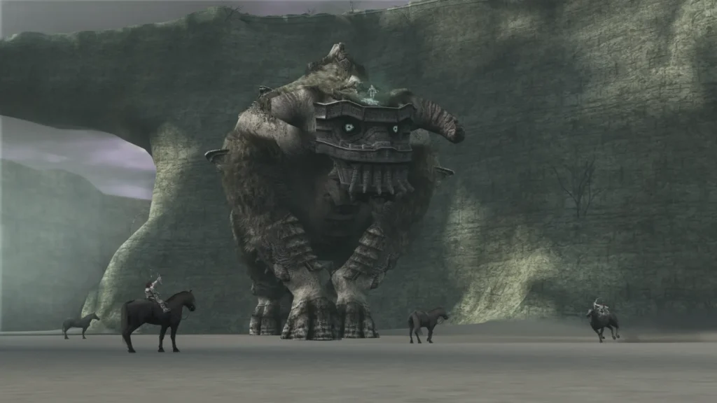 Tres jinetes observan a un coloso gigante en Shadow of the Colossus emergiendo entre acantilados brumosos en la costa.
