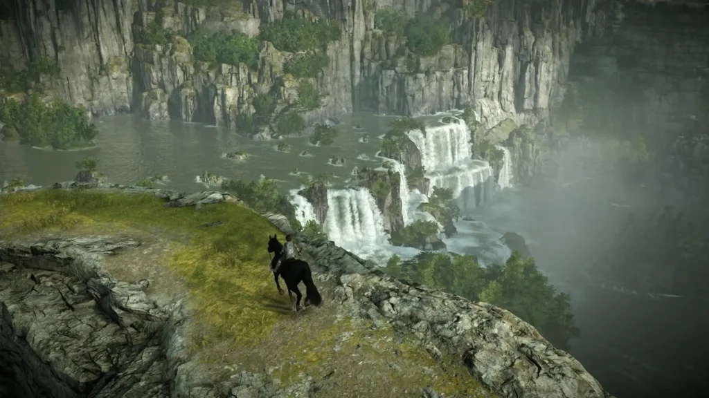 Wander cabalga por un precipicio rocoso contemplando cascadas y valles en el vasto mundo de Shadow of the Colossus.