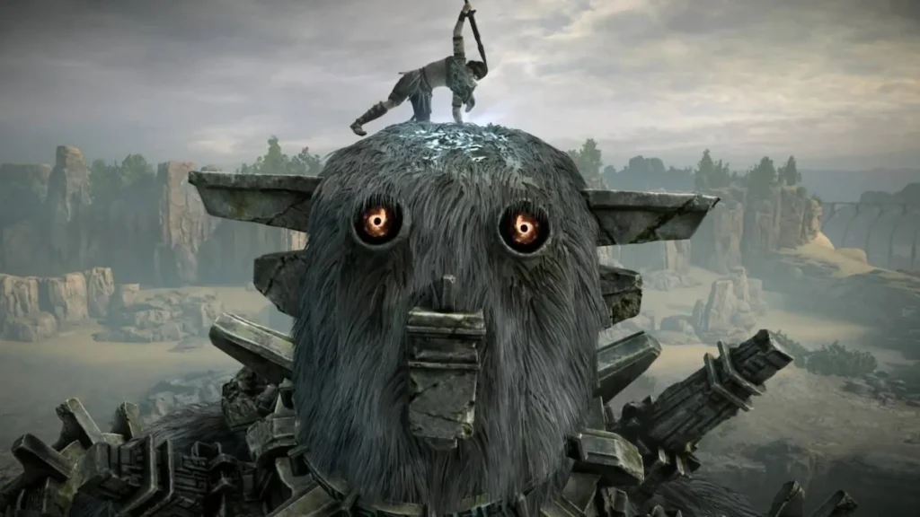Wander clava su espada sobre la cabeza peluda de un coloso mientras sus ojos brillan en Shadow of the Colossus.