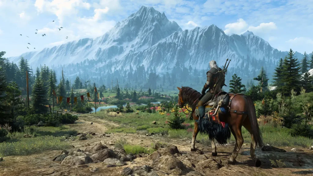 El realismo en The Witcher 3 y el realismo fantástico 5 Un paisaje muy bello, con montañas al fondo y árboles, junto a un jinete en su caballo a punto de recorrerlos, demostrando el realismo en The Witcher 3.