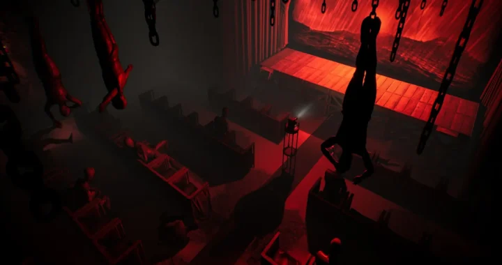 Un teatro macabro de Layers of Fear 2 muestra maniquíes colgados y figuras inmóviles bajo una luz roja inquietante.