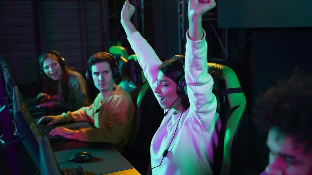 Mujer gamer levanta los brazos celebrando la victoria en una competición de eSports.