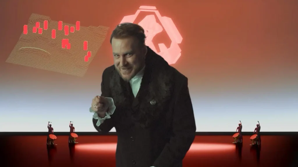 Un actor que interpreta a un villano, sonriendo diabólicamente, se dirige a la cámara en una escena FMV de Dying Breed con un símbolo rojo y un mapa en rejilla.