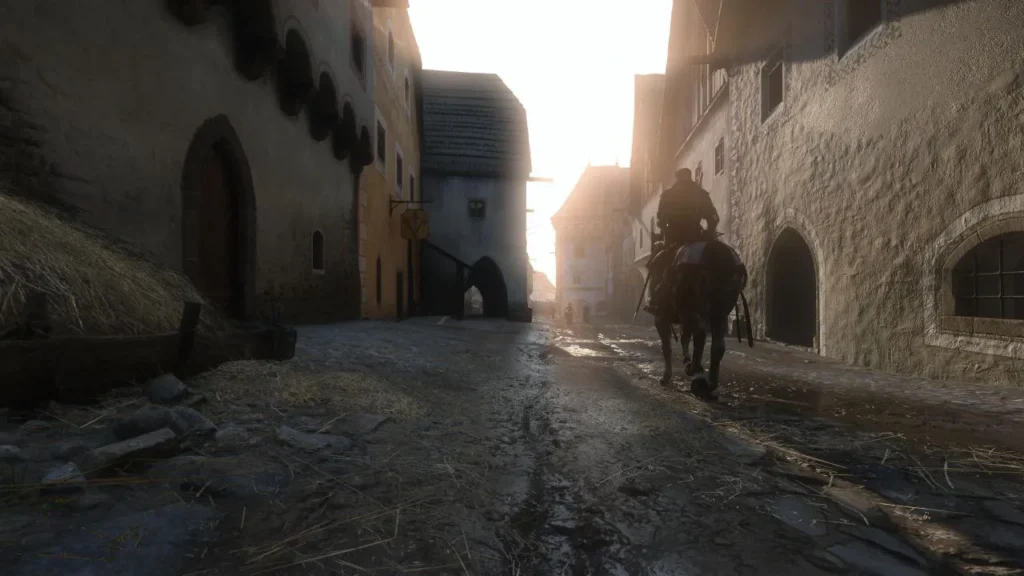 Jinete a caballo recorre una calle embarrada al amanecer entre casas de piedra, atmósfera histórica inmersiva de Kingdom Come: Deliverance II.