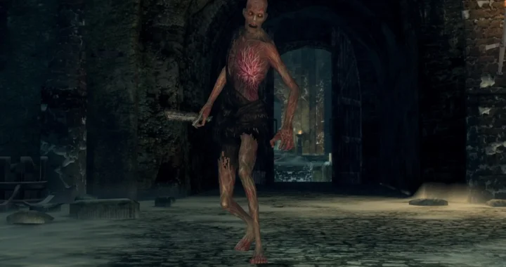 Un enemigo no-muerto con venas expuestas avanza armado por una mazmorra oscura de Dark Souls.