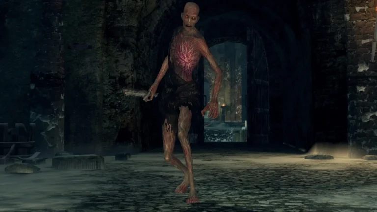 Un enemigo no-muerto con venas expuestas avanza armado por una mazmorra oscura de Dark Souls.